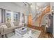 Bright living room featuring hardwood floors, a staircase, and large windows providing ample natural light at 2602 E 145Th Ave, Thornton, CO 80602