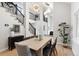 Bright dining room featuring hardwood floors, modern chandelier, and staircase with black metal railings at 4505 S Yosemite St # 362, Denver, CO 80237