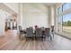 A modern dining room filled with natural light featuring a large table, elegant chairs, and sleek, contemporary light fixture at 14545 Lipan St, Westminster, CO 80023