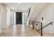 Bright entryway featuring a modern black front door, open staircase, and beautiful wood-look floors at 14545 Lipan St, Westminster, CO 80023