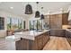 A modern kitchen features an island with a white countertop and dark wood cabinets, along with pendant lighting at 14545 Lipan St, Westminster, CO 80023