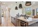 A modern kitchen island with dark wood cabinets, gray countertop, and stainless steel oven is open to the dining area at 14545 Lipan St, Westminster, CO 80023