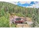 Stunning aerial view of a home with expansive decks nestled in a dense forest at 1774 Upper Bear Creek Rd, Evergreen, CO 80439