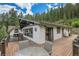 Large outdoor patio with seating offering picturesque views of the surrounding landscape and blue skies at 1774 Upper Bear Creek Rd, Evergreen, CO 80439