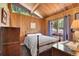 Warm bedroom with wood paneling, exposed beams, and a window showcasing outdoor views at 1774 Upper Bear Creek Rd, Evergreen, CO 80439