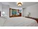Bright bedroom featuring a window with views of lush greenery and wood paneling at 1774 Upper Bear Creek Rd, Evergreen, CO 80439