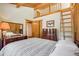 Charming bedroom with exposed beam ceiling and ladder access to loft space at 1774 Upper Bear Creek Rd, Evergreen, CO 80439