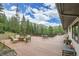 Expansive deck showcasing views of the surrounding woods. Features built-in seating and an outdoor grill at 1774 Upper Bear Creek Rd, Evergreen, CO 80439