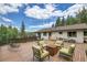 Wide view of a large outdoor deck with seating and a fire pit, perfect for entertaining and enjoying scenic views at 1774 Upper Bear Creek Rd, Evergreen, CO 80439