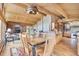 Spacious dining area with wood ceilings, wood furnishings, and an open kitchen at 1774 Upper Bear Creek Rd, Evergreen, CO 80439