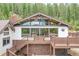 Close up of the exterior with large windows and multiple decks with detailed railings at 1774 Upper Bear Creek Rd, Evergreen, CO 80439