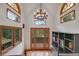 Elegant foyer with a chandelier and hardwood floors, showcasing a seamless transition to the outdoors at 1774 Upper Bear Creek Rd, Evergreen, CO 80439
