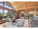 Cozy living room featuring a brick fireplace, wood ceilings, and nature views at 1774 Upper Bear Creek Rd, Evergreen, CO 80439
