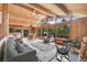 Inviting living room boasts wood ceilings, many windows, plush seating, and serene views at 1774 Upper Bear Creek Rd, Evergreen, CO 80439