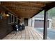 Covered outdoor seating area with stone accents and view of garage for relaxing and entertaining at 1774 Upper Bear Creek Rd, Evergreen, CO 80439