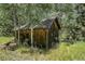 Rustic shed with wooden exterior and flower boxes blending into the nature providing privacy at 1774 Upper Bear Creek Rd, Evergreen, CO 80439