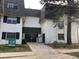 Attractive multi-Gathering building with muted white brick, black shutters, sign, and bench for residents and visitors at 5875 E Iliff Ave # 203, Denver, CO 80222