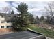 Condo building with view of mature evergreens and a playground in the distance at 5875 E Iliff Ave # 203, Denver, CO 80222