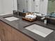 Bathroom vanity features a modern faucet, dual sinks, and a sleek gray countertop with fresh towels on a wooden tray at 1898 S Bannock St # 209, Denver, CO 80223
