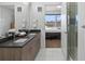 Bathroom with dual sink vanity, contemporary fixtures, and a tiled shower at 1898 S Bannock St # 209, Denver, CO 80223