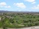 Scenic aerial shot of the lush golf course set against the backdrop of distant mountains at 1898 S Bannock St # 209, Denver, CO 80223
