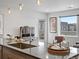 Kitchen island with sleek countertop, sink, pendant lights, and access to a patio at 1898 S Bannock St # 209, Denver, CO 80223