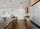 Modern kitchen with stainless steel appliances, wooden cabinets, and ample counter space at 1898 S Bannock St # 209, Denver, CO 80223