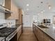 Open kitchen with wood floors, sleek appliances, island, and access to bedroom and living area at 1898 S Bannock St # 209, Denver, CO 80223