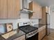 Gourmet kitchen with stainless steel range, hood, sleek countertop and wood cabinets at 1898 S Bannock St # 209, Denver, CO 80223