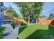Well-maintained backyard featuring a lush lawn, a patio with outdoor seating, and a charming detached garage at 706 S Lincoln St, Denver, CO 80209