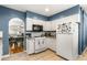 Bright kitchen featuring white cabinets, tile flooring, and open access to the dining area at 706 S Lincoln St, Denver, CO 80209