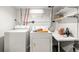 Functional laundry area with a washer, dryer, utility sink and storage shelves at 706 S Lincoln St, Denver, CO 80209