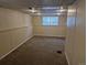 Unfinished basement space features carpeting, a window for natural light, and paneled walls at 4678 S Lewiston Way, Aurora, CO 80015