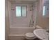 Bathroom with white tiled walls, a tub/shower combination, and a pedestal sink at 4678 S Lewiston Way, Aurora, CO 80015