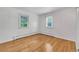Clean bedroom with hardwood floors, baseboard heating, and natural light from two windows at 505 Maple St, Golden, CO 80403
