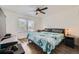 Cozy bedroom with a ceiling fan, large window, and a comfortable quilt on the bed at 9300 E Florida Ave # 1101, Denver, CO 80247