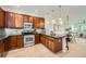 Well-lit kitchen features stainless steel appliances, wood cabinets and a breakfast bar with pendant lighting at 9300 E Florida Ave # 1101, Denver, CO 80247
