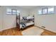 A bedroom featuring a bunk bed, hardwood floors, and two bright windows at 7950 Maria St, Westminster, CO 80030