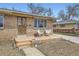 Charming brick home featuring a cozy front porch with two chairs and a well-maintained yard at 7950 Maria St, Westminster, CO 80030