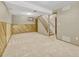 Spacious basement area with carpet, wood-paneled wall, and stairs leading to the upper level at 2675 S Carson Way, Aurora, CO 80014