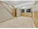 Basement with carpet and wood-paneled accent wall featuring a staircase and windows at 2675 S Carson Way, Aurora, CO 80014
