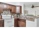 Modern kitchen with tile backsplash, white appliances, wood cabinets and stylish hardware at 3300 W Florida Ave # 117, Denver, CO 80219