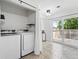 Bright laundry room with modern washer and dryer, and sliding glass door at 3300 W Florida Ave # 117, Denver, CO 80219