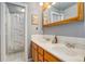 This bathroom features a double sink vanity, light wood cabinetry, and a shower with decorative curtain at 1428 S County Road 23E, Berthoud, CO 80513