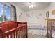 Cozy bedroom with a crib, accent wall and natural light from the window at 1428 S County Road 23E, Berthoud, CO 80513