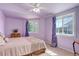 Comfortable bedroom with light purple walls, large windows, and natural light at 1428 S County Road 23E, Berthoud, CO 80513