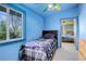 Blue bedroom with a ceiling fan and a view into the adjacent bedroom at 1428 S County Road 23E, Berthoud, CO 80513