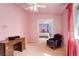 This pink-walled bedroom is furnished with an antique desk, plush chair, and views into the next bedroom at 1428 S County Road 23E, Berthoud, CO 80513