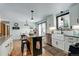 Well-lit kitchen with white cabinets, modern island with seating, stainless appliances, and hardwood floors at 1428 S County Road 23E, Berthoud, CO 80513