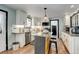Modern kitchen with white cabinets, stainless steel appliances, central island, and hardwood flooring at 1428 S County Road 23E, Berthoud, CO 80513